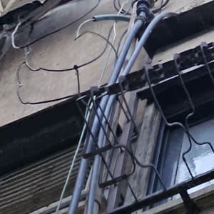 כבלים חשמליים מחוברים לקיר חיצוני של בניין