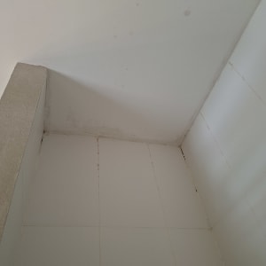 פינת חדר עם אריחים וקיר לבן