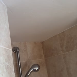 מקלחת עם אריחים וראש מקלחת מתכתי