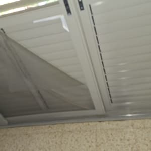 תריסים עם רשת קרועה על חלון