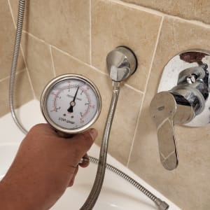 מד לחץ מים מחובר לצינור במקלחת