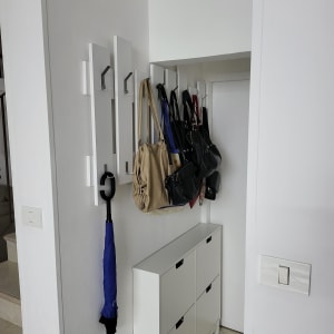 מתלים על קיר עם תיקים ומטריה תלויים