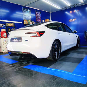 מכונית לבנה בחדר כחול עם ציוד ניקוי