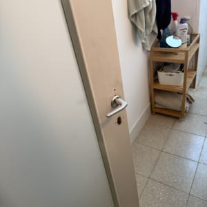 דלת עם ידית חסרה בחדר אמבטיה