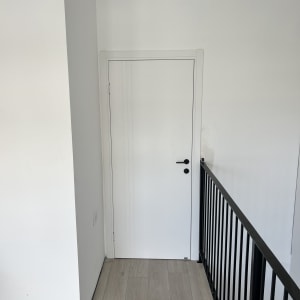 דלת לבנה עם ידית שחורה במסדרון