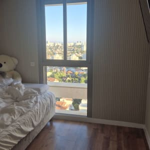 חדר שינה עם רצפת פרקט ונוף מהחלון