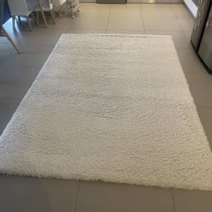 שטיח לבן על רצפת מטבח עם ארונות ומקרר