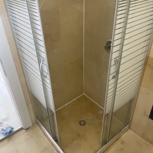 מקלחון זכוכית עם דלתות הזזה וידיות מתכת