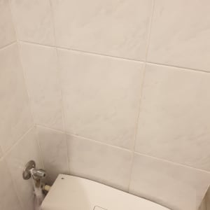 קיר אריחים לבנים עם חיבורי צנרת