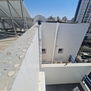 צינורות על גג בניין עם קולטי שמש