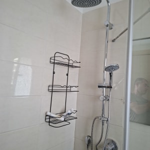מקלחת עם ראש מקלחת ומדף מתכת