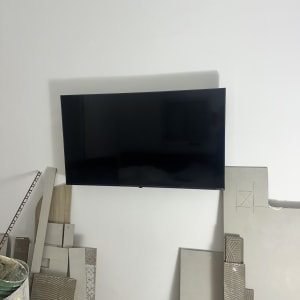 טלוויזיה מותקנת על קיר עם אריחים וכלי עבודה