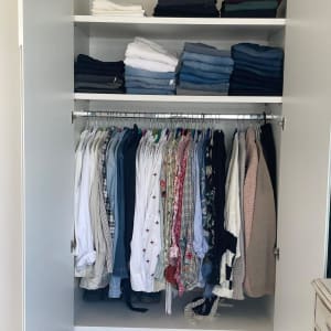 ארון בגדים מסודר עם בגדים מקופלים ותלויים