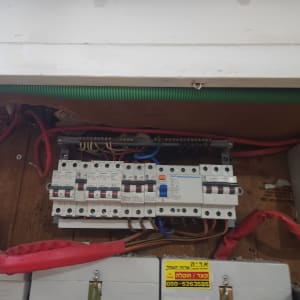 לוח חשמל עם מפסקים וחוטים חשמליים אדומים