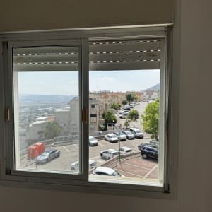 חלון עם נוף של חניה ובניינים