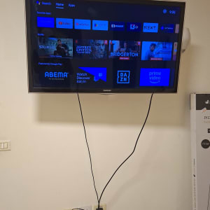 טלוויזיה מותקנת על הקיר עם כבלים חשמליים גלויים