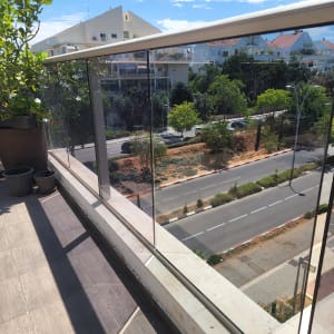 מעקה זכוכית במרפסת עם נוף לעיר