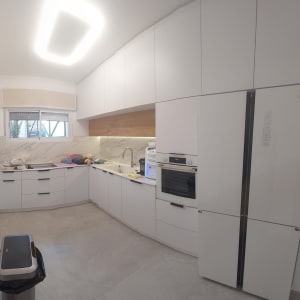 מטבח חדש עם ארונות לבנים ותנור בנוי