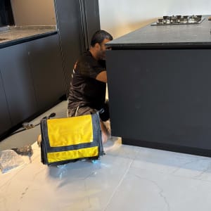 אדם עובד על התקנת מטבח עם כלי עבודה