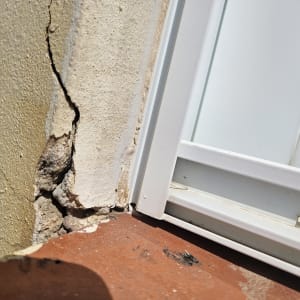 סדק בקיר ליד חלון לבן