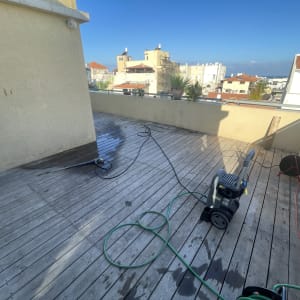 מכונת שטיפה בלחץ על דק עץ במרפסת