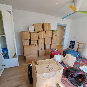 חדר עם קופסאות קרטון, מזוודות וארון פתוח