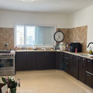 מטבח עם ארונות כהים ומכשירי חשמל
