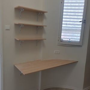 מדפים מעץ עם תומכים מתכתיים על קיר