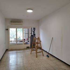 סולם ומטאטא בחדר עם קירות לבנים