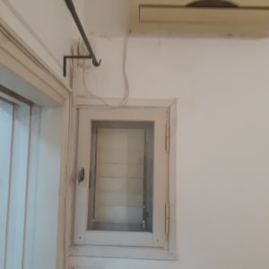 קיר עם מזגן וחלון קטן