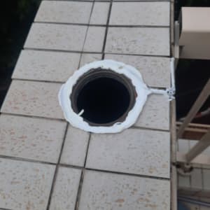 חור עגול ברצפה עם איטום לבן סביבו