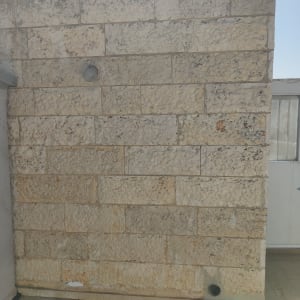 קיר אבן עם צינור קטן בתחתית