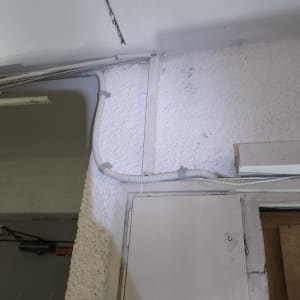 צינור חשמל גמיש מותקן על קיר לבן