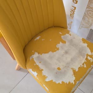 כיסא צהוב עם ריפוד מתקלף ונזק