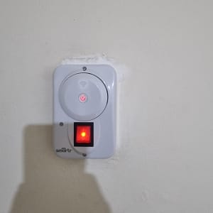 מתג חכם על קיר עם נורית חיווי אדומה