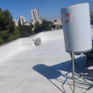 גג אטום עם ציפוי לבן ומיכל מים
