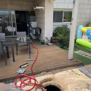 אדם עובד בבור עם צינור אדום וכלי עבודה