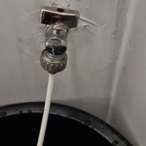 ברז מתכת עם צינור לבן מחובר