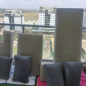 כריות וספות על מרפסת עם נוף לבניינים