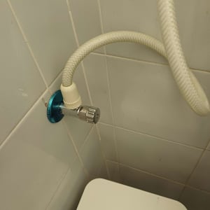 צינור מים מחובר לקיר בחדר אמבטיה