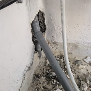 צינור מים מותקן בקיר עם חור ותשתית חשופה