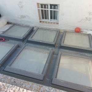 חלונות זכוכית אטומים עם מסגרות מתכת על גג