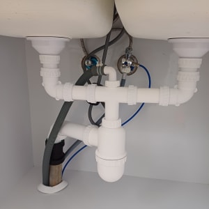 צנרת פלסטיק מתחת לכיור עם חיבורים