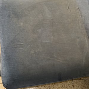 ניקוי ספה עם מכשיר שאיבה על רצפת אריחים