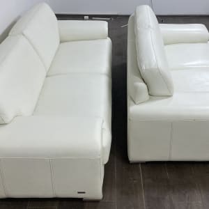 שתי ספות עור לבנות נקיות על רצפת עץ כהה