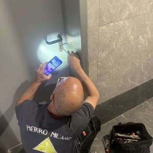 מנעולן עובד על מנעול דלת עם כלים ותאורה