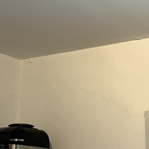 פינה של קיר עם סדקים קטנים ותקרה