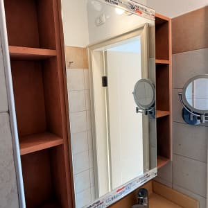 מראה עם מסגרת עץ בחדר אמבטיה