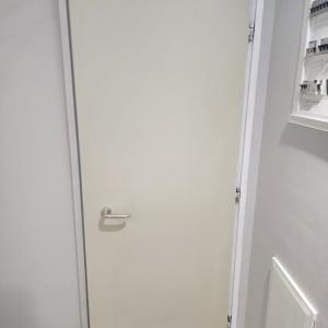 דלת עם ידית זהב על רקע קיר אפור