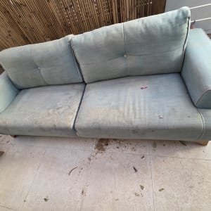 ספה מלוכלכת עם כתמים על הרצפה